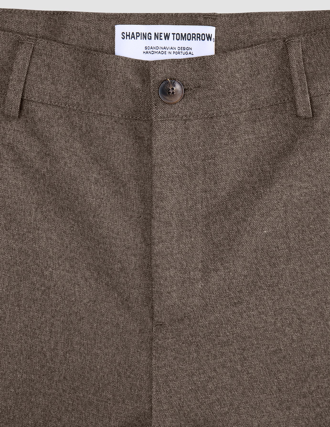 Nærbilde av linningen, knappen og midtsømmen på de mørkbeige Atelier Pants Relaxed.